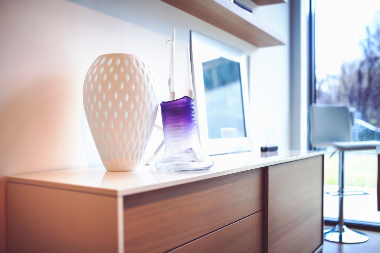 services-01 A stylish modern interior featuring decorative vases on a wooden sideboard, exuding contemporary design.